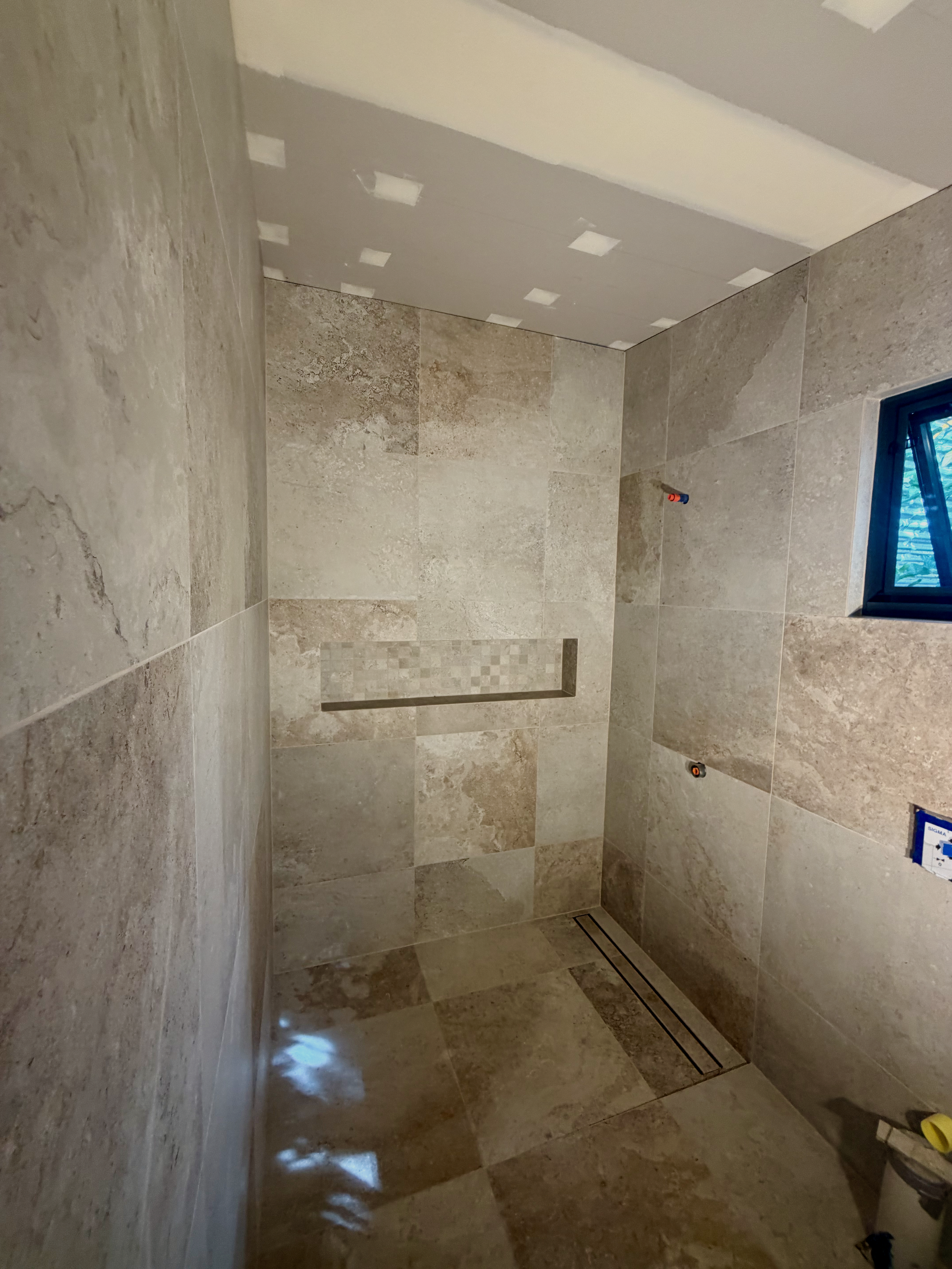 Contemporary shower area with large format wall tiles and frameless glass